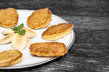 Sweet pancakes on a plate on a wooden table