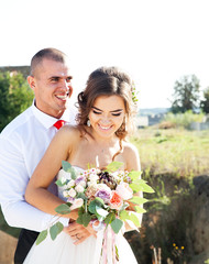 Beautiful, young newlywed couple walking in nature. Wedding