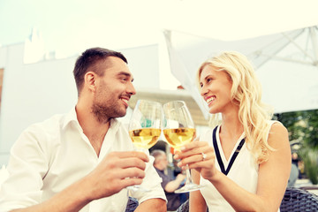 happy couple drinking wine at open-air restaurant