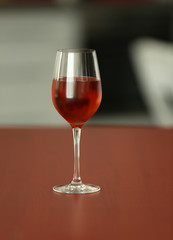 Glass with red wine on table