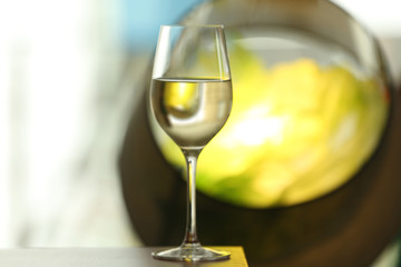 Glass with white wine on table