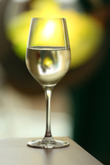 Glass with white wine on table