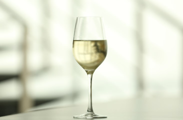 Glass with white wine on table