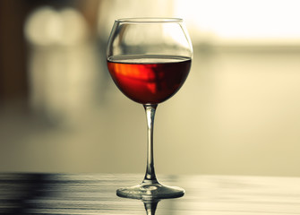 Glass with red wine on table