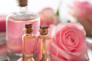 Obraz na płótnie Canvas Bottles of aroma oil with flower roses, closeup