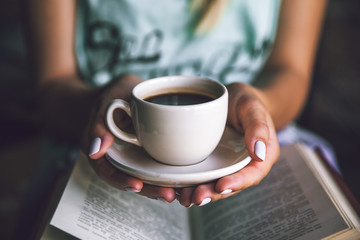 Girl with a cup of coffee and a book. Wakes up, morning, break,