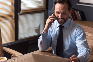 Pleasant hard working manager having a phone conversation