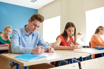Obraz premium group of students with books writing school test