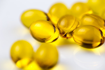 Fish oil capsules on white. Selective focus.