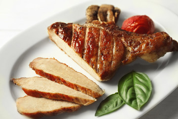 Grilled meat with vegetables on plate, closeup