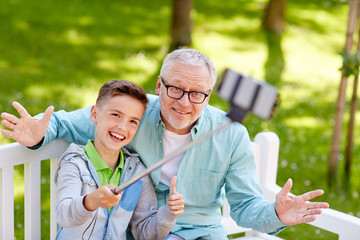 old man and boy taking selfie by smartphone