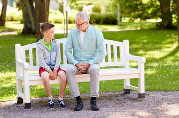 grandfather and grandson talking at summer park