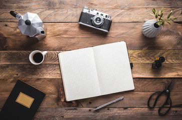 writer, photographer, artist, hipster wooden rustic desk with black notebook, camera, coffee maker and cup of espresso. Flat lay. View from above, copy space.