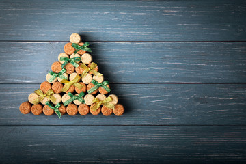 Christmas tree made of cork plugs and ribbons on wooden background