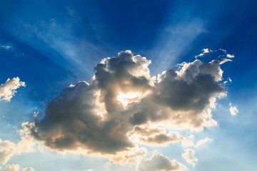 Sun rays on blue sky background with clouds