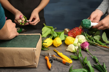Female hands making beautiful flower composition in floral shop