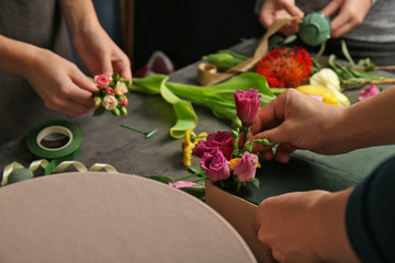 Female hands making beautiful flower composition in floral shop