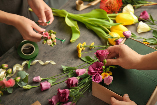 Female hands making beautiful flower composition in floral shop