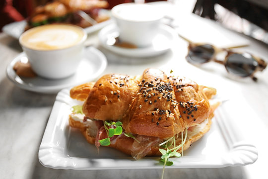 Breakfast With Croissant Sandwich And Coffee On Table