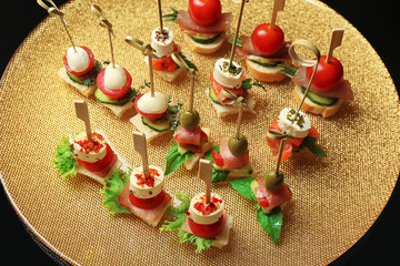 Set of delicious canapes on metal tray closeup