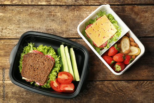 "Lunch boxes with food on wooden background, top view ...