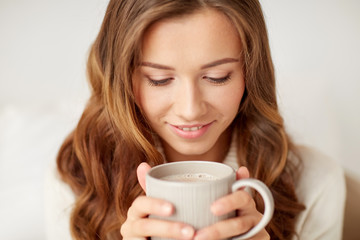 close up of happy woman with coffee cup at home