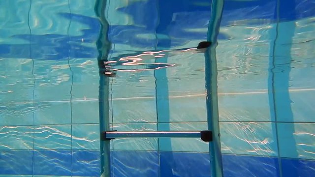 A step ladder underwater in a swimming pool