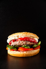 classic burger with meat on a black background
