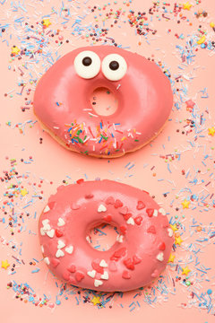 Funny glazed donuts on pink background