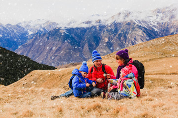 Fototapeta na wymiar family with two kids travel in scenic winter mountains