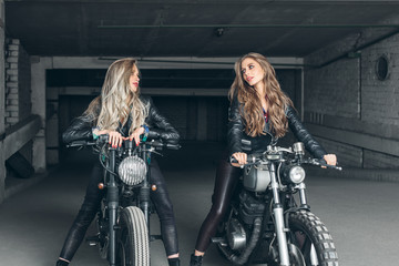 Naklejka na ściany i meble Bikers women in leather jackets with motorcycles