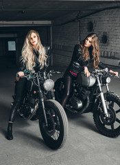 Naklejka na ściany i meble Bikers women in leather jackets with motorcycles