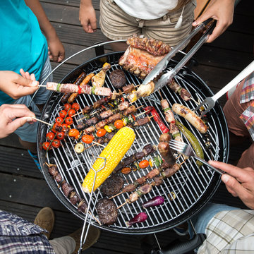 Top view of friend hands serving food, barbecue garden party
