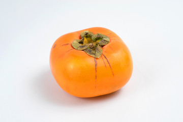 Close up of a ripe and squared persimmon on white background