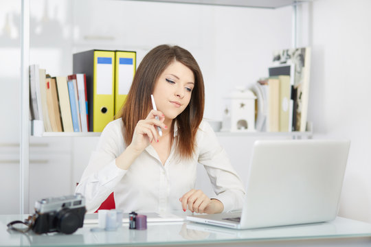 Young woman photo reporter sitting in front of desktop computer