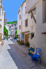 Traditional European Mediterranean architectural style in the streets and residential houses at summertime. Flowerpots stand on the stone steps.