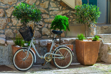 Traditional European Mediterranean architectural style in the streets and residential houses at summertime. Flowerpots stand on the stone steps.