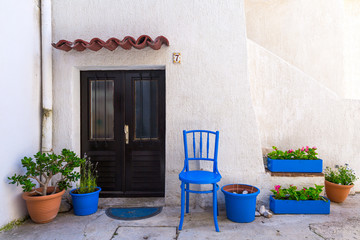 Fototapeta na wymiar Traditional European Mediterranean architectural style in the streets and residential houses, porches, stairs, shutters in the noon sunbeam, surrounded by vine, hydrangea and palm at summertime. Baska