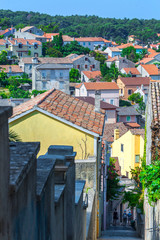Obraz premium Traditional European Mediterranean architectural style in the streets and houses, yard, porches, stairs, shutters in the afternoon sunbeam, surrounded by vine, hydrangea and palm at summer Mali Losinj