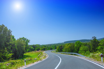 Beautiful asphalt freeway, motorway, highway without traffic through of southern landscape mountains forest during summer on a sunny day. Travel road concept.