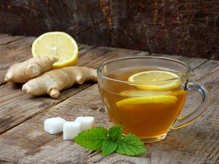 cup of tea with ginger and lemon on a wooden background