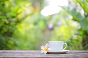 Obraz na płótnie Canvas white cup and frangipani flower at outdoor