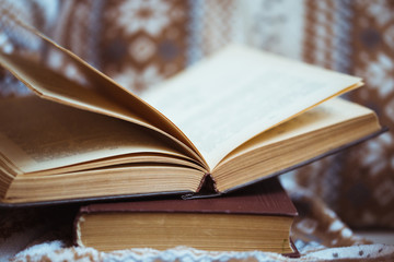 Stack of books with warm plaid on chair