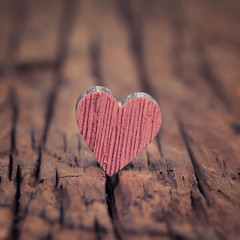 Fototapeta premium Pink wooden valentines heart on an old rustic wood