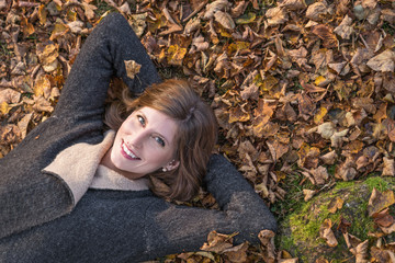 Portrait of a attractive Woman, lying on autumn leaves