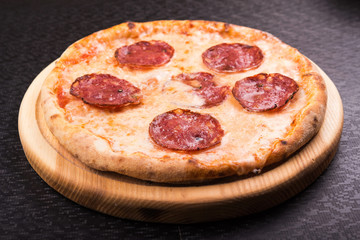 hot pepperoni pizza on wooden board