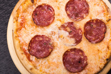 hot pepperoni pizza on wooden board