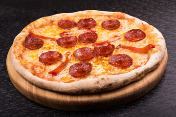 hot pepperoni pizza on wooden board