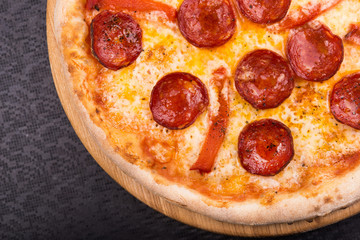 hot pepperoni pizza on wooden board