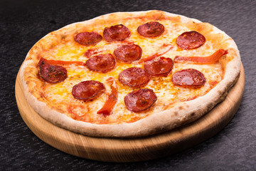 hot pepperoni pizza on wooden board